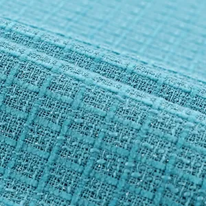 Détail du tissu en tweed bleu aqua montrant la texture tissée et les paillettes