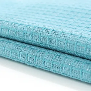 Gros plan de tissu en tweed bleu clair de style Chanel avec fils pailletés argent