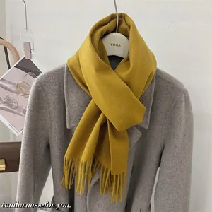 Vue détaillée d'une écharpe en laine jaune avec de longues franges élégantes