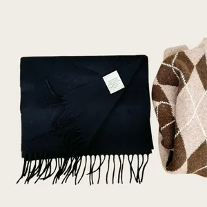 Close-up detail of 100% Australian wool scarf in navy blue featuring soft tassels and label