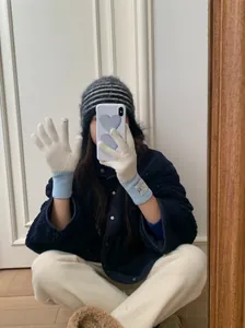Gros plan détaillé des gants en laine de style coréen avec poignets bleus et étiquette ours