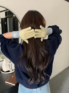 Vue arrière d'une femme portant des gants en tricot jaune et bleu pour l'hiver