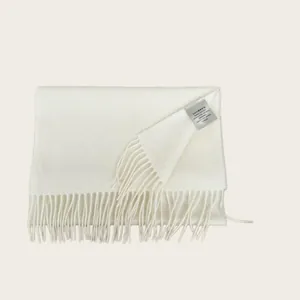 Detail of a premium white 100% Australian wool scarf with soft fringes and tag.
