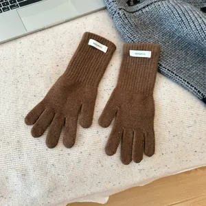 Detail shot showing texture of brown 100% merino wool knitted winter gloves for women