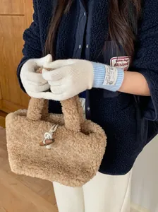 Vue détaillée de gants en laine tricotée crème avec poignets côtelés bleu clair portés