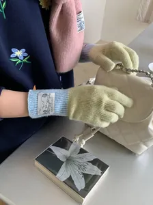 Détail de gants en laine tricotée souple au design color-block bleu et vert