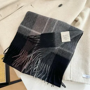 Close-up detail of 100% Australian wool plaid scarf with fringes placed on a beige coat