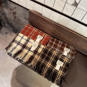 Vue détaillée de quatre écharpes à carreaux colorées avec des glands sur un banc