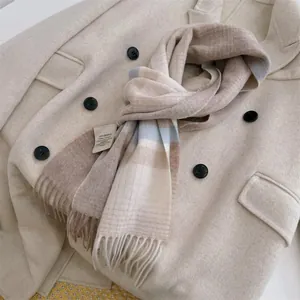 Close-up of 100% Australian wool plaid scarf with tassel detail and fabric label
