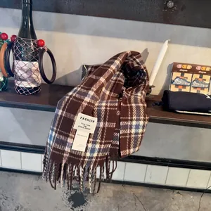 Détail d'une écharpe à carreaux marron et bleu avec de douces franges en boutique