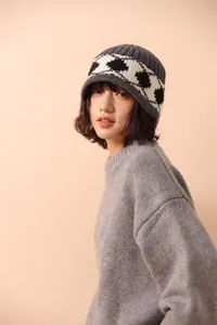 Detailed close-up showing the soft wool texture and Nordic diamond pattern of the grey beanie.