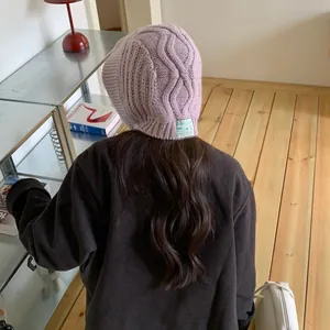 Stylish back view of a cozy purple knitted winter trapper hat with warm earflaps