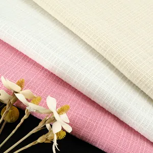 Close-up of pink white and cream checkered tweed fabric showing detailed woven texture
