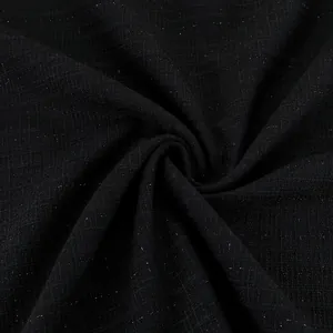 Macro view of black checkered tweed fabric with subtle sparkling metallic threads.