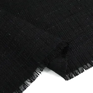 Macro detail of black checkered tweed fabric with fringe edge for fashion garments