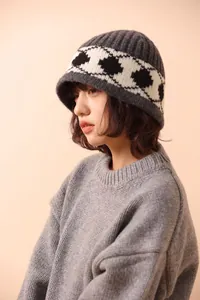Side view detail of a vintage wool knitted bucket hat with black diamond pattern