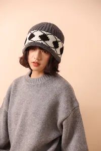 Model wearing a vintage gray wool beanie with black and white argyle pattern