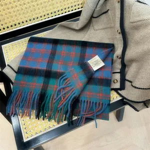 Close-up of a plaid 100% Australian wool scarf with fringe and a fabric label.