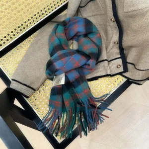 Close-up of 100% wool plaid scarf with orange and blue checks and tassels.