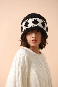 Detail of a woman wearing a vintage geometric knit wool beanie in black and white.
