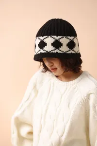 Close-up of a vintage black and white argyle wool knit hat on a model
