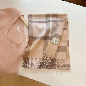 Detail view of a vintage pumpkin brown plaid 100% wool scarf with soft tassels