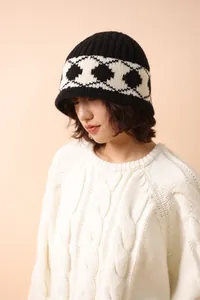 Detail shot of a warm wool knit bucket hat with retro diamond pattern on model