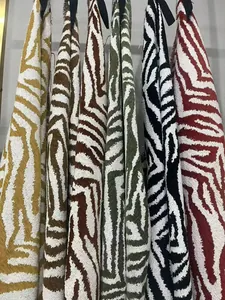 Vista dettagliata del tessuto ciniglia jacquard con motivo zebrato di lusso in vari colori.