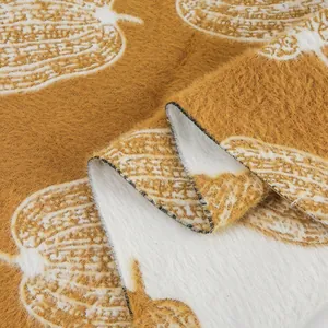 Gros plan de velours de vison doux avec motif citrouille pour couvertures et pyjamas.