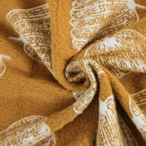 Gros plan détaillé sur un tissu en velours de vison jaune moutarde à motif de citrouille