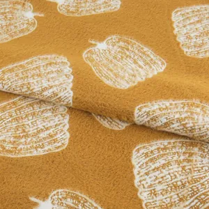 Gros plan sur un tissu doux en velours de vison jaune moutarde avec motif de citrouille