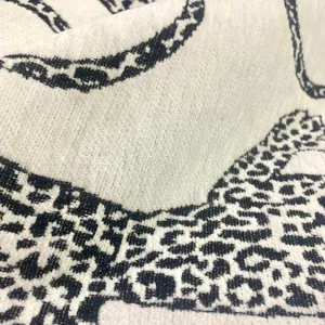 Macro detail of white chenille jacquard fabric with black leopard leopard print