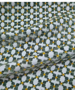 Detailed texture of green and white vintage jacquard fabric with geometric patterns.
