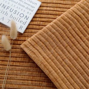 Gedetailleerde macro-opname van chenille bankstof met verticale strepen in bruin.