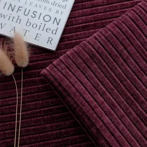Macro-detail van wijnrode geribbelde chenille bankstof met diepe textuur en ribbels