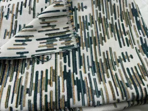 Dettaglio macro del tessuto jacquard in ciniglia con motivo geometrico color oro