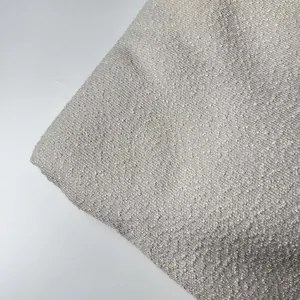 Macro view of thick beige bouclé yarn fabric texture for upholstery and pillows.