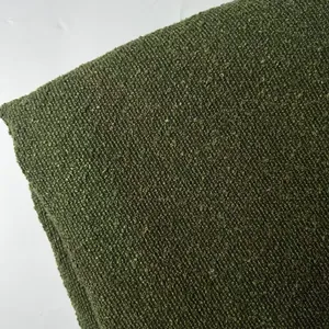 Close-up of thick olive green bouclé yarn fabric with textured loop weave detail.