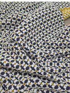 Detailed macro shot of vintage jacquard fabric with black, white, and gold geometric pattern.