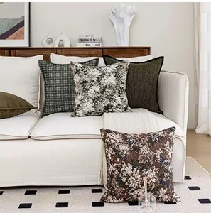 Assortiment de coussins jacquard vintage à fleurs et carreaux sur canapé blanc