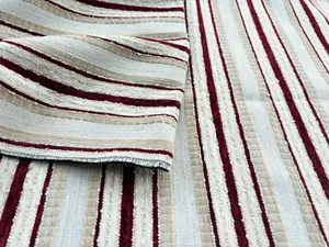 Detaillierte Makroansicht von hochwertigem rot-beigem gestreiftem Jacquard-Chenille-Stoff.