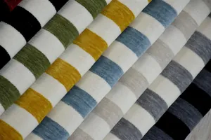 Dettaglio di rotoli di tessuto ciniglia a righe spesse multicolore per arredamento