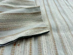 Detaillierte Makroansicht der Textur von beige-grau gestreiftem Jacquard-Polstermöbelstoff