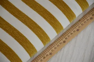 Primo piano di tessuto in ciniglia a righe gialle e bianche con un righello di legno