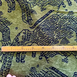 Detail view of green chenille fabric with tiger pattern and measuring ruler for scale