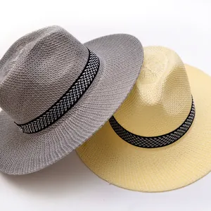 Detailansicht von zwei geflochtenen Strohhüten in Grau und Creme mit Musterband.