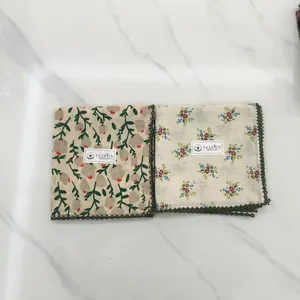 Detailed view of vintage cotton floral handkerchiefs with dark green lace trim.