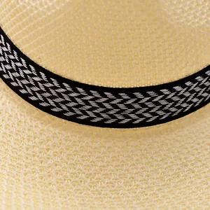 Makroaufnahme der Textur eines Sommerstrohhutes mit dekorativem schwarzem Band.