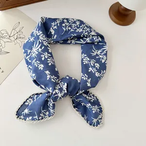 Close-up of blue cotton floral square scarf with elegant lace trim details.