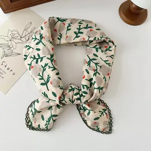 Close-up of floral cotton scarf with dark green lace trim and vintage leaf print